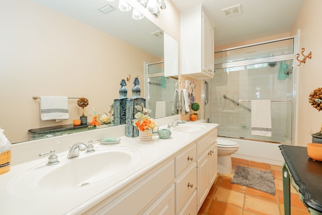 full bathroom featuring bath / shower combo with glass door, vanity, and toilet