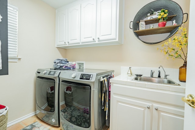 washroom featuring light tile patterned floors, cabinets, sink, and washing machine and clothes dryer