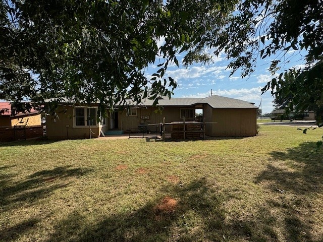 rear view of house featuring a lawn