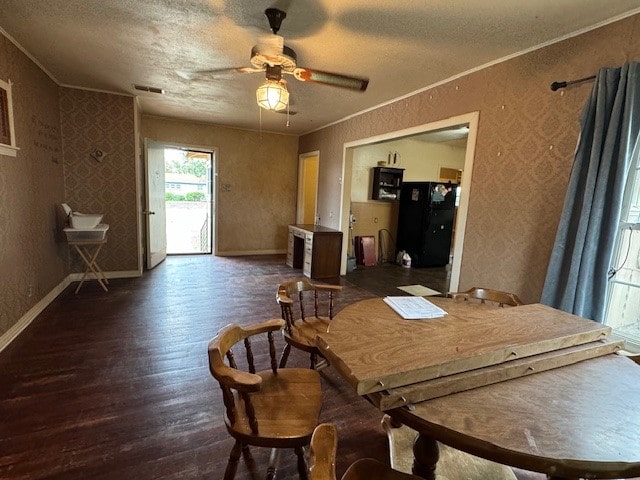 dining room with dark wood-type flooring, ceiling fan, a textured ceiling, and ornamental molding