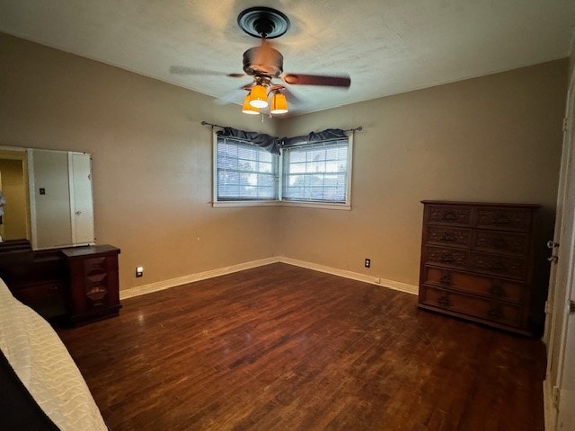 unfurnished bedroom featuring ceiling fan and dark hardwood / wood-style floors