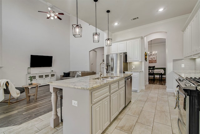 kitchen with tasteful backsplash, a kitchen island with sink, white cabinetry, and stainless steel appliances