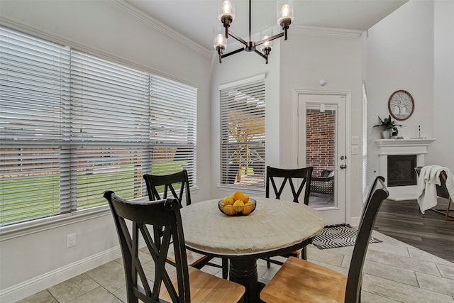 dining area with crown molding, light tile patterned flooring, and an inviting chandelier