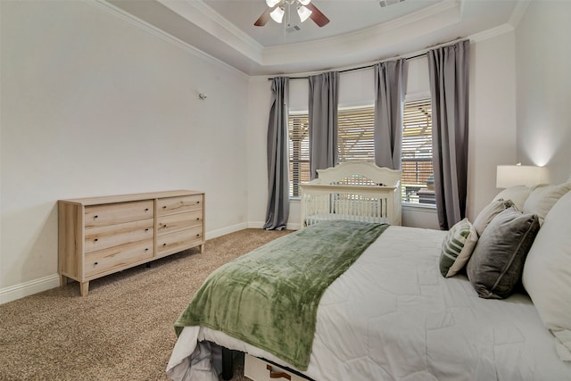 carpeted bedroom featuring a tray ceiling, ceiling fan, and ornamental molding