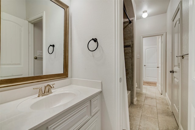 bathroom featuring tile patterned flooring, vanity, and tiled shower / bath