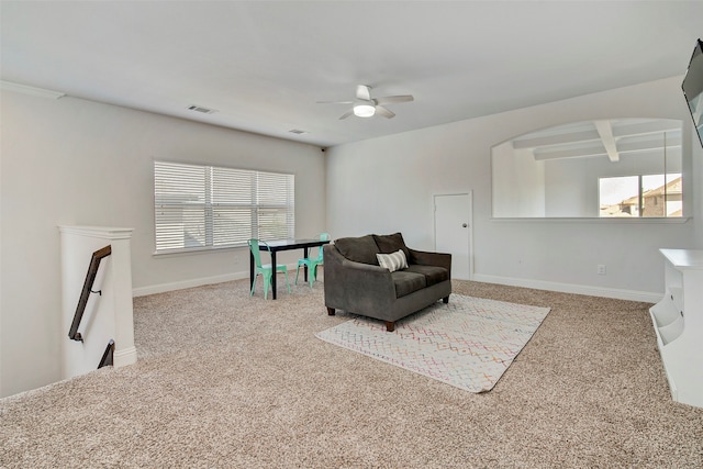 sitting room featuring beam ceiling, ceiling fan, and carpet floors