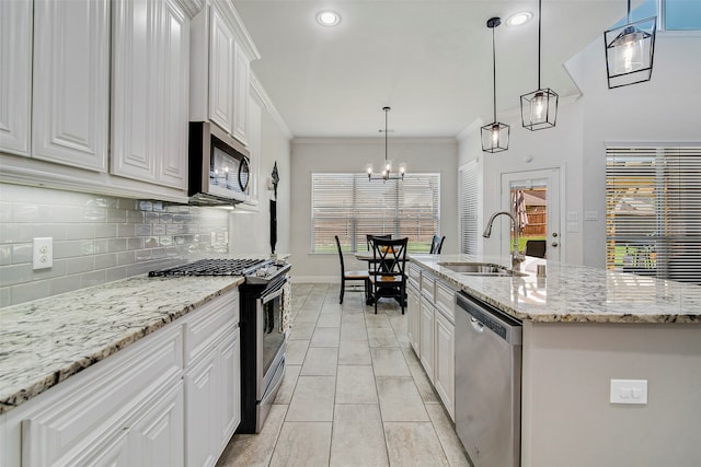 kitchen with pendant lighting, white cabinets, sink, an island with sink, and stainless steel appliances