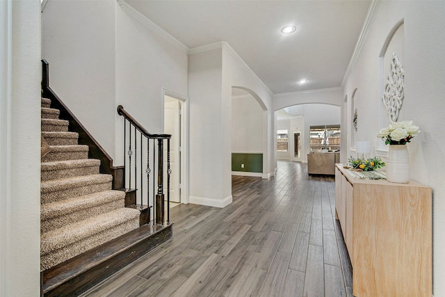 foyer entrance featuring ornamental molding and dark wood-type flooring