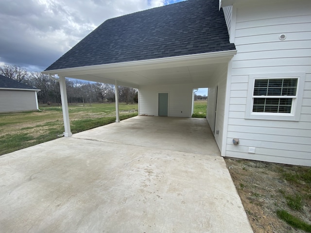 view of parking / parking lot featuring a yard and a carport