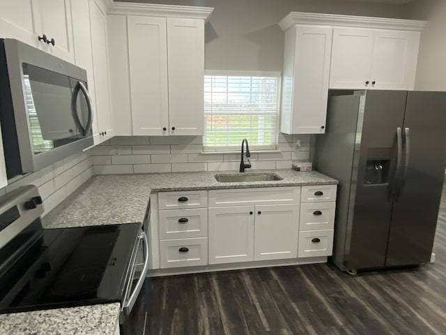 kitchen with tasteful backsplash, sink, stainless steel appliances, dark hardwood / wood-style floors, and white cabinetry