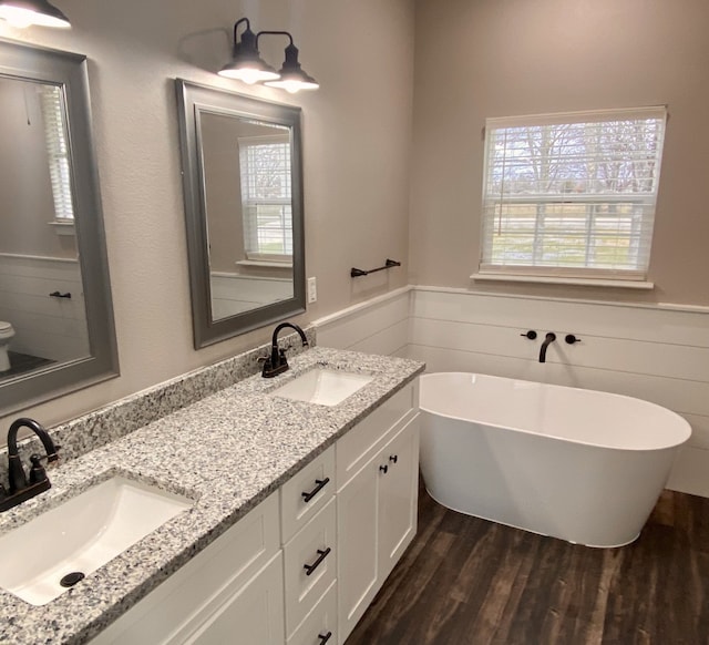 bathroom featuring hardwood / wood-style floors, a tub, and vanity