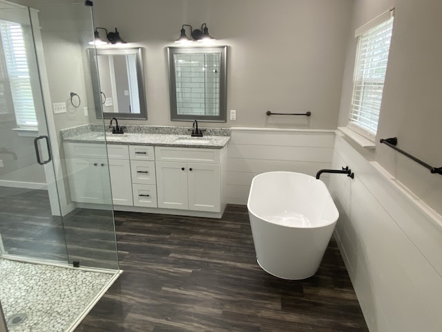 bathroom with independent shower and bath, vanity, tile walls, and hardwood / wood-style floors