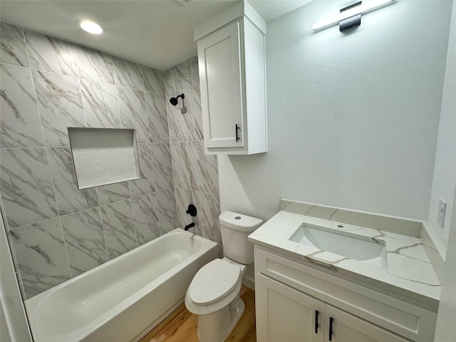 bathroom featuring bathtub / shower combination, toilet, recessed lighting, wood finished floors, and vanity