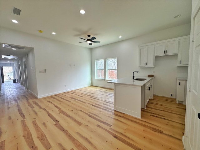 kitchen with visible vents, light wood finished floors, recessed lighting, a ceiling fan, and a sink