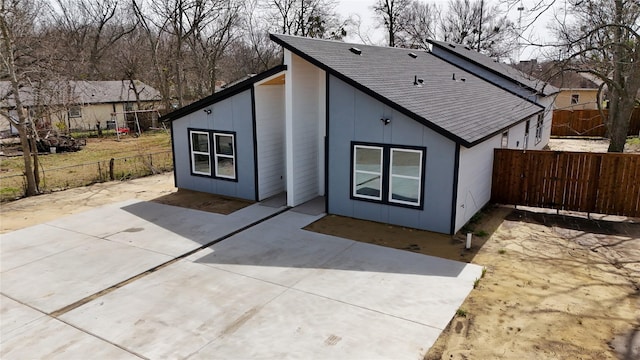 exterior space featuring a patio, roof with shingles, and a fenced backyard