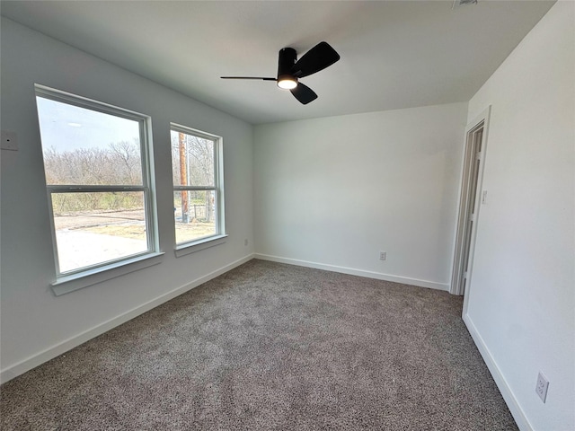 carpeted empty room with a ceiling fan and baseboards