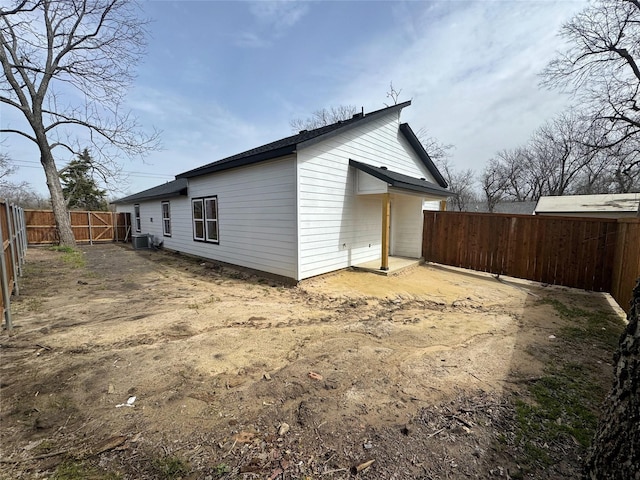 rear view of house with central AC, a gate, and a fenced backyard