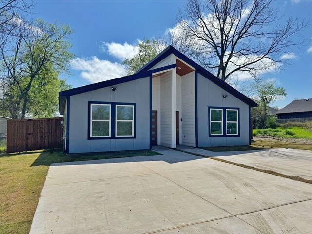 view of front facade with a front yard, fence, and a patio