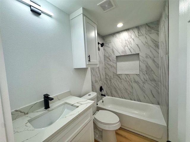 full bath with toilet, wood finished floors, vanity, visible vents, and  shower combination