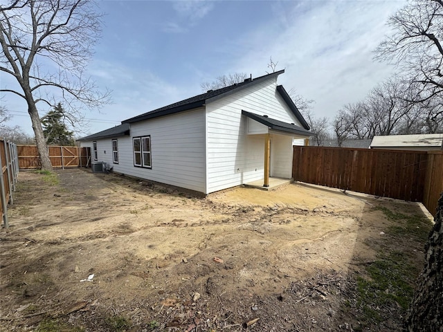 rear view of property with a gate, a fenced backyard, and central air condition unit