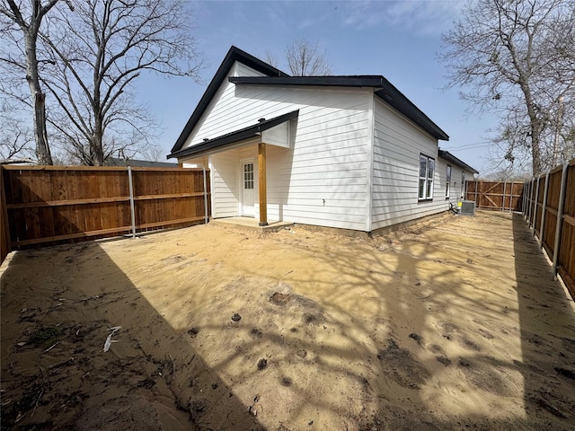 rear view of house featuring central air condition unit and a fenced backyard