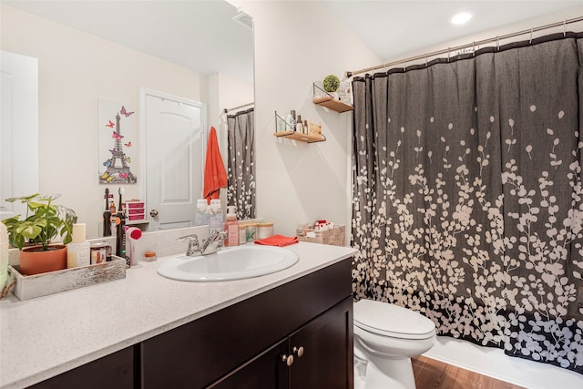 full bathroom featuring hardwood / wood-style flooring, vanity, shower / bath combo with shower curtain, and toilet