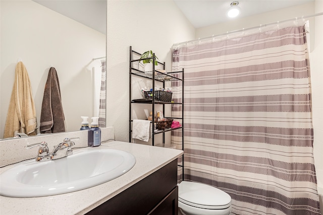 bathroom with toilet, walk in shower, and vanity