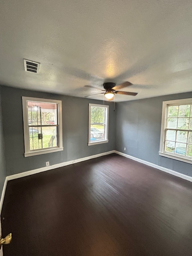 spare room featuring plenty of natural light, ceiling fan, hardwood / wood-style flooring, and a textured ceiling