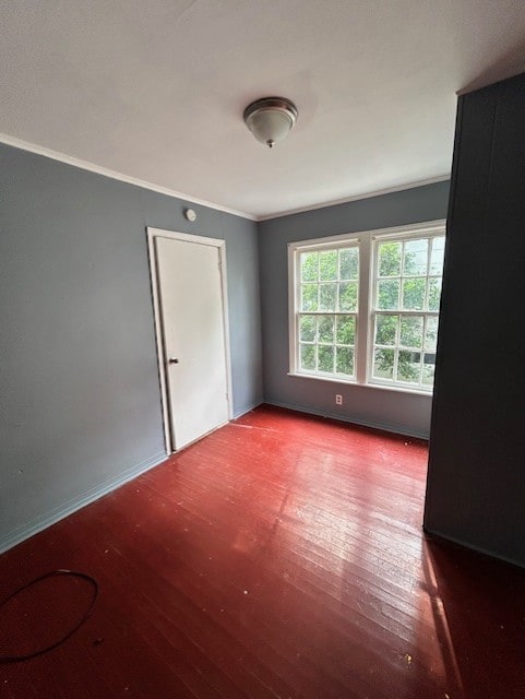 spare room with wood-type flooring and ornamental molding