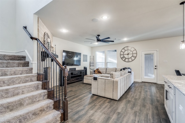 living room featuring dark wood-type flooring and ceiling fan