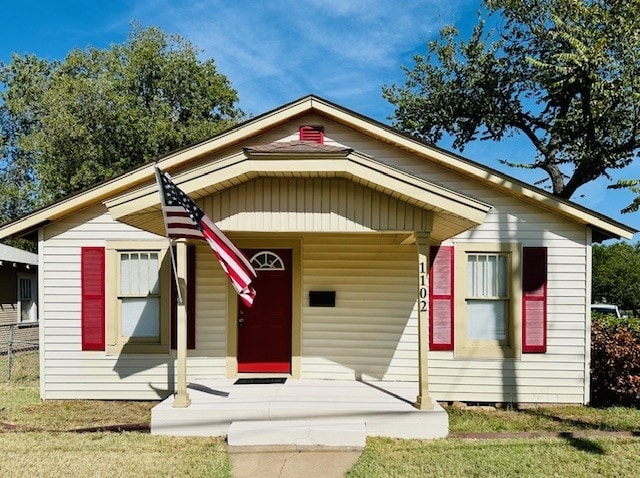 bungalow with a porch and a front yard