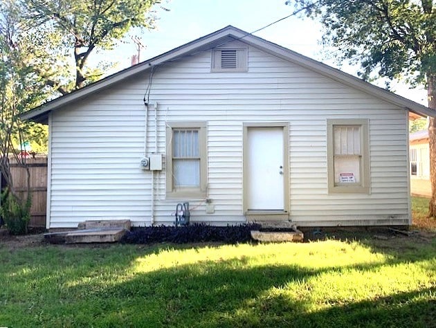 back of property featuring a yard