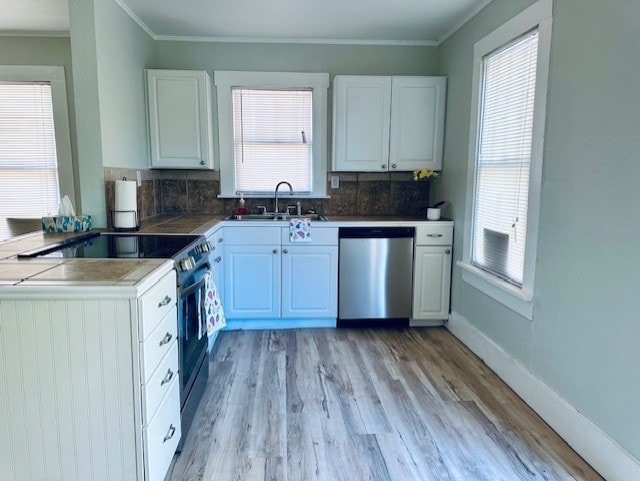 1102 S 14th St, Abilene, TX 79602 - kitchen featuring stainless steel appliances, a sink, tasteful backsplash, white cabinets, and crown molding