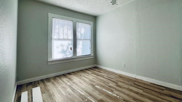 1102 S 14th St, Abilene, TX 79602 - spare room with a textured ceiling, wood finished floors, baseboards, a ceiling fan, and a textured wall