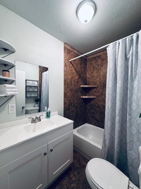 full bathroom with toilet, vanity, shower / bath combo with shower curtain, and a textured ceiling