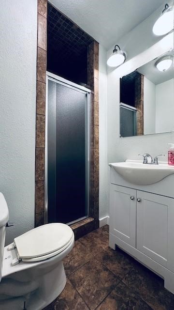 bathroom featuring vanity, toilet, and an enclosed shower