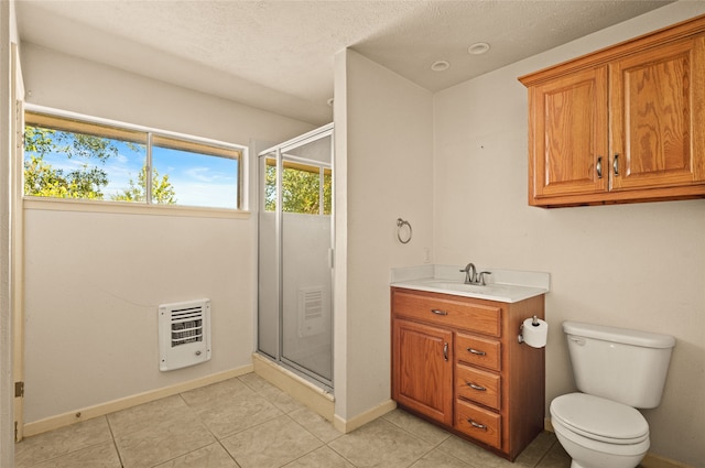 bathroom with vanity, an enclosed shower, a textured ceiling, heating unit, and toilet