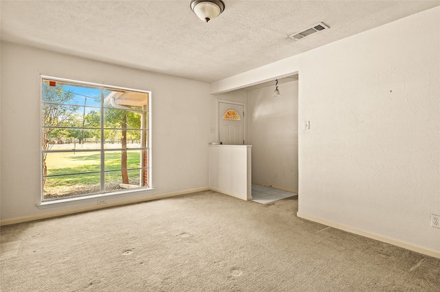 carpeted spare room with a textured ceiling