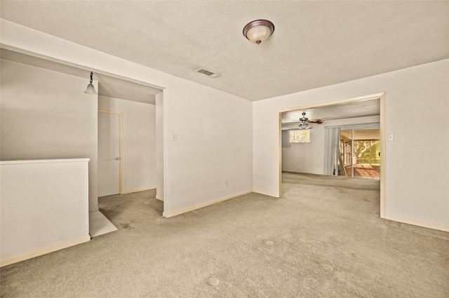 carpeted empty room featuring a textured ceiling and ceiling fan