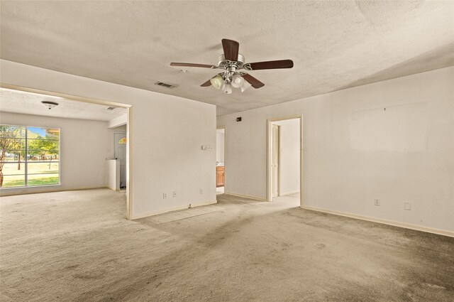 carpeted empty room with ceiling fan and a textured ceiling