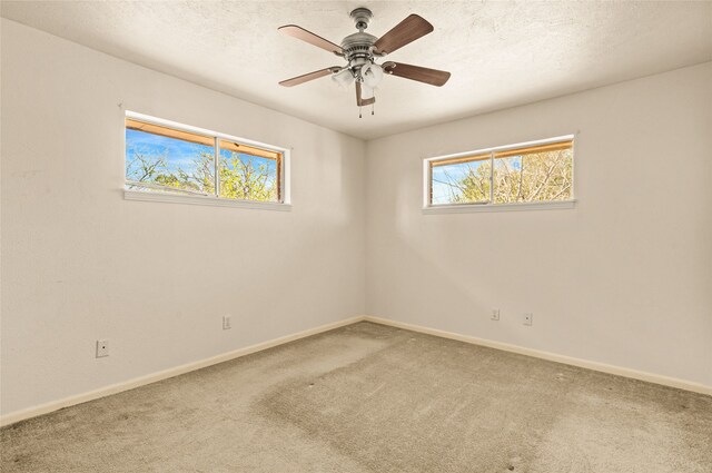 empty room with ceiling fan, a textured ceiling, and carpet flooring