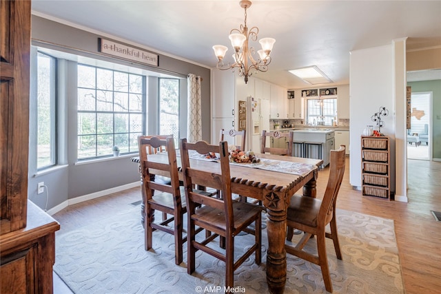 dining room with plenty of natural light, light wood-type flooring, and ornamental molding