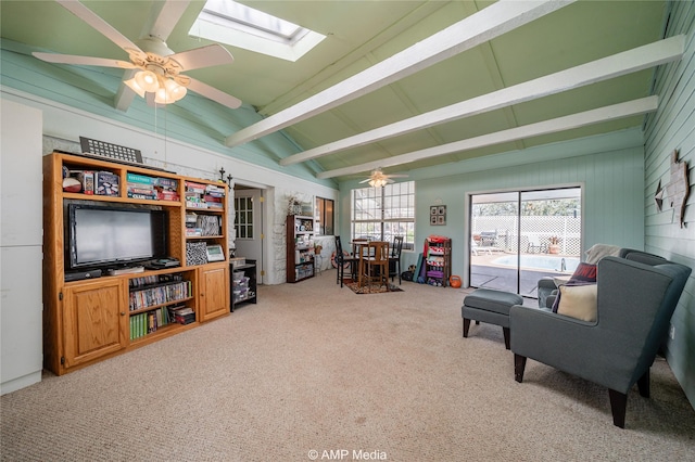 interior space featuring lofted ceiling with skylight, carpet floors, and ceiling fan