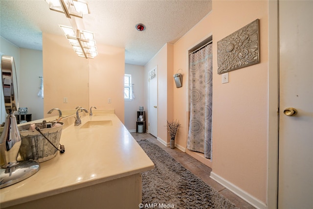 bathroom with a textured ceiling, vanity, tile patterned floors, and curtained shower