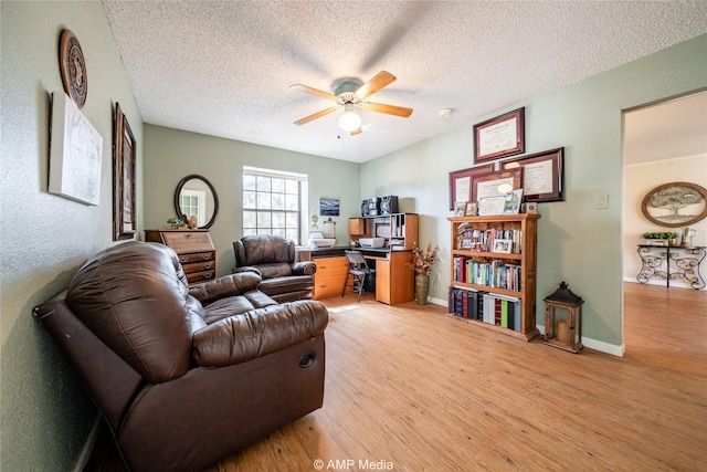 living room featuring a textured ceiling, light hardwood / wood-style flooring, and ceiling fan