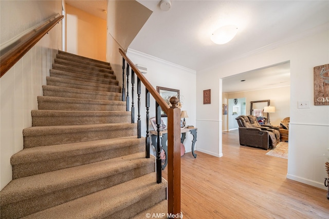 staircase featuring hardwood / wood-style floors and crown molding