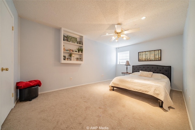 bedroom featuring ceiling fan, carpet floors, and a textured ceiling