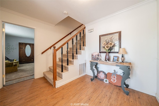 stairway featuring hardwood / wood-style flooring and crown molding