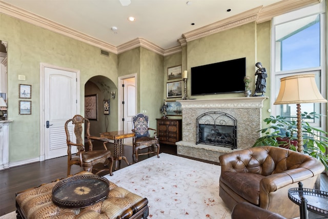 living room featuring a fireplace, crown molding, and hardwood / wood-style floors