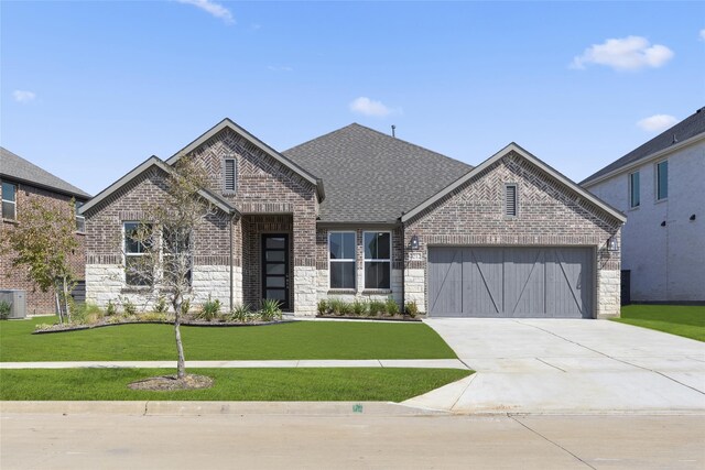 view of front facade featuring cooling unit, a garage, and a front lawn